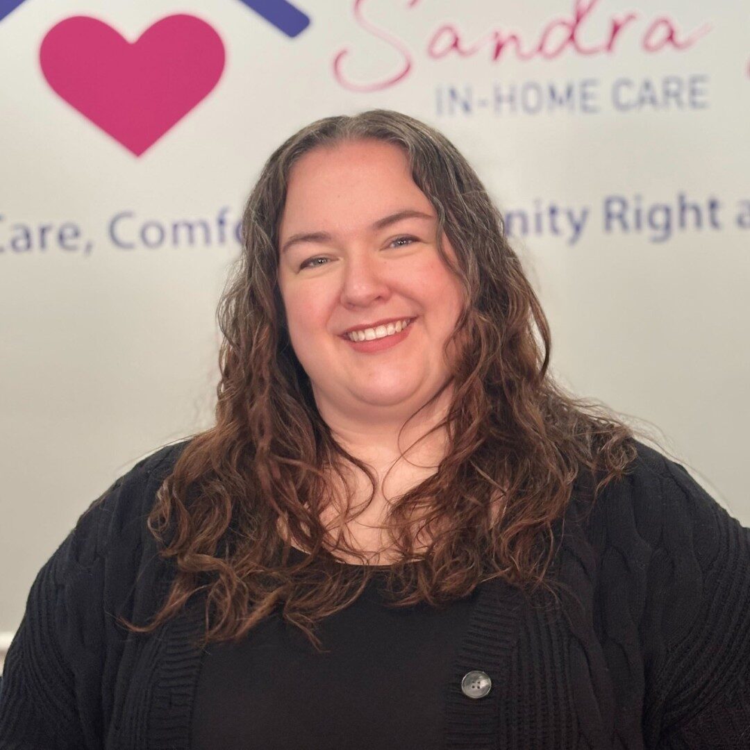 Smiling woman in front of care service logo.