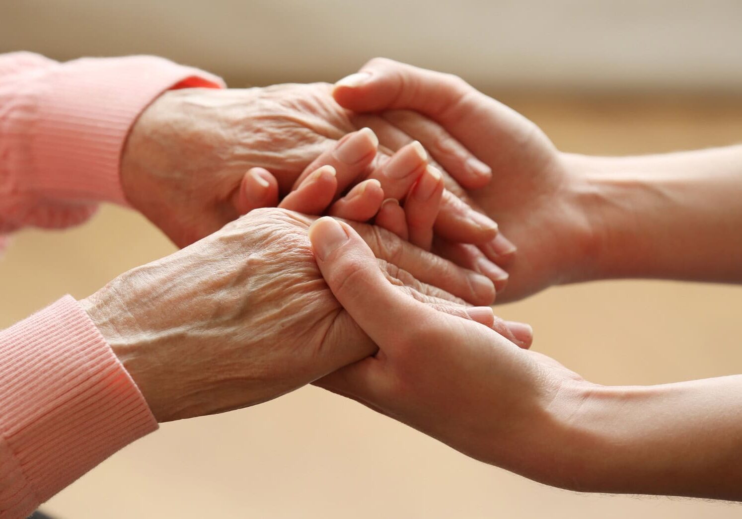 Elderly and young hands in comforting gesture.