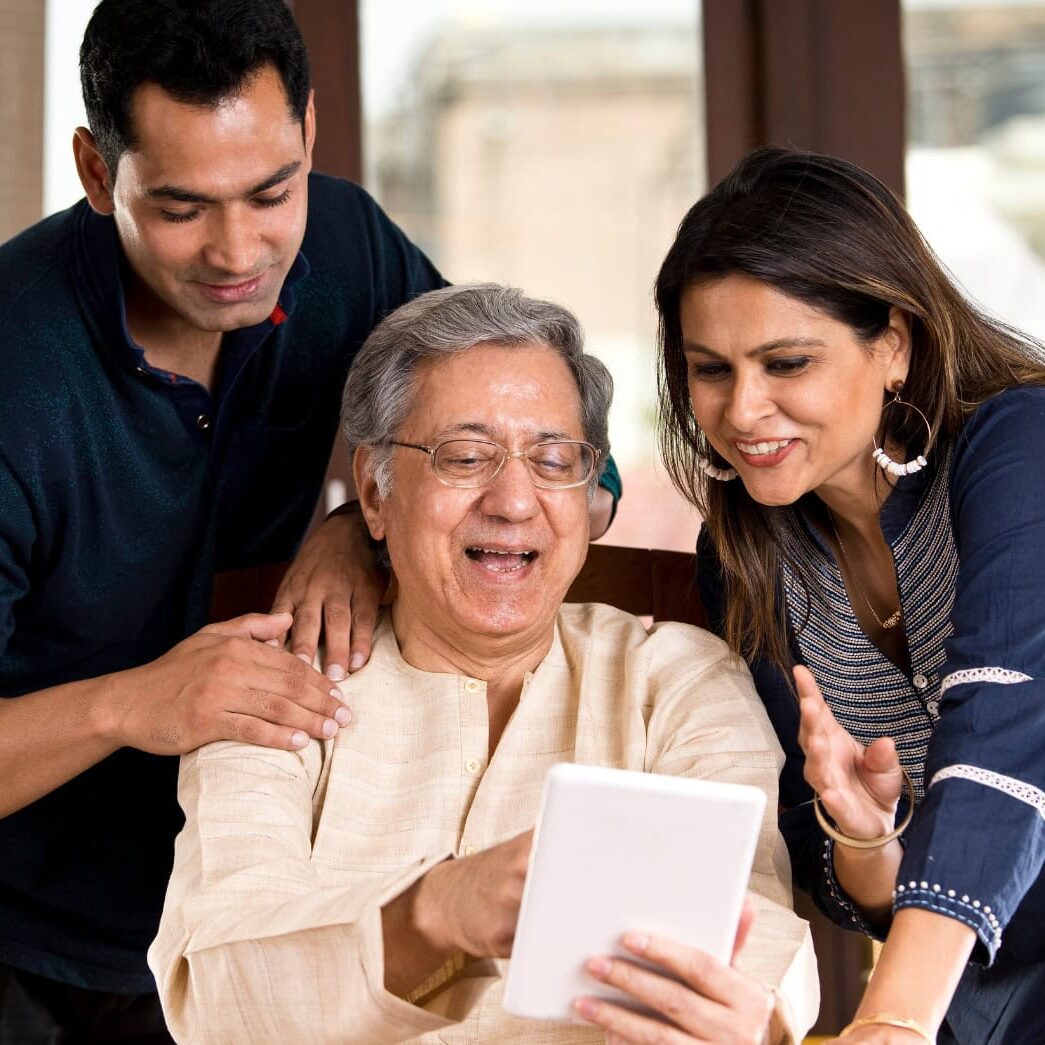 Family smiling while using a tablet together